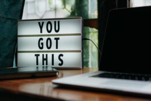 "You got this" sign on a desk with a laptop.