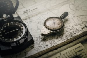 A neat, metal compass lying on a map