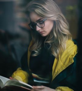 Photo: Woman looking down at an open book by Ryan Jacobson on Unsplash